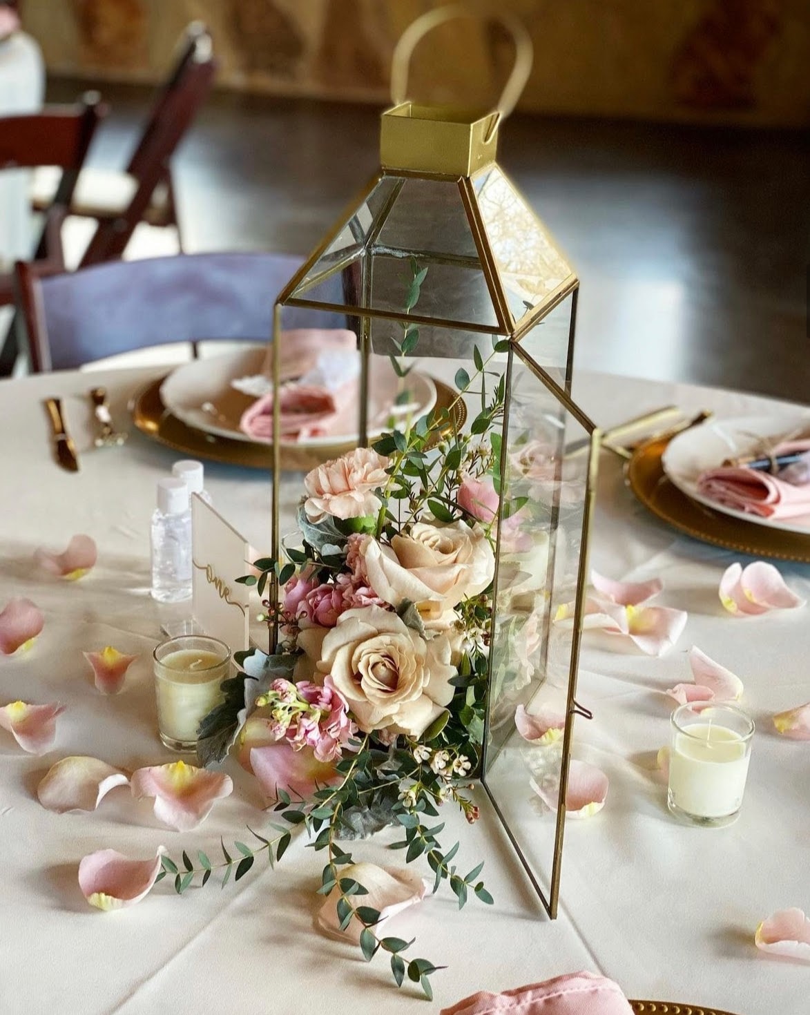 gold lantern with pink flowers as a wedding guest table centerpiece